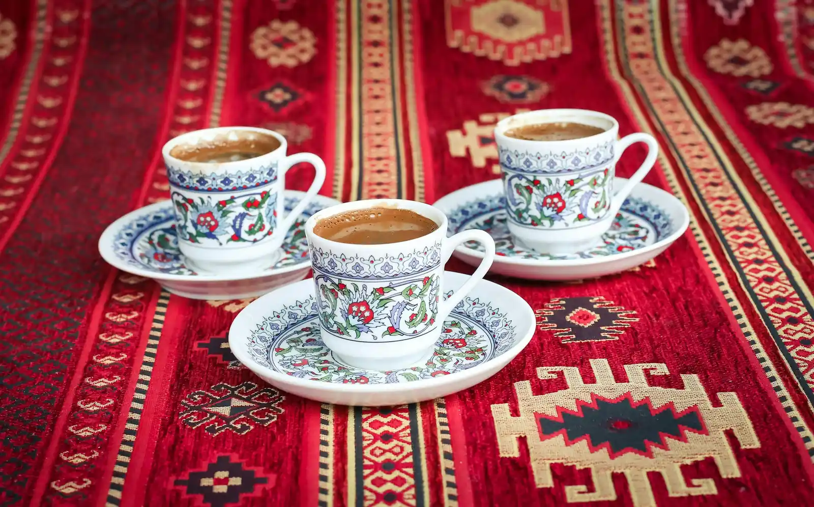 Kırmızı kilim üzerinde işlemeli fincanlarda Türk kahvesi