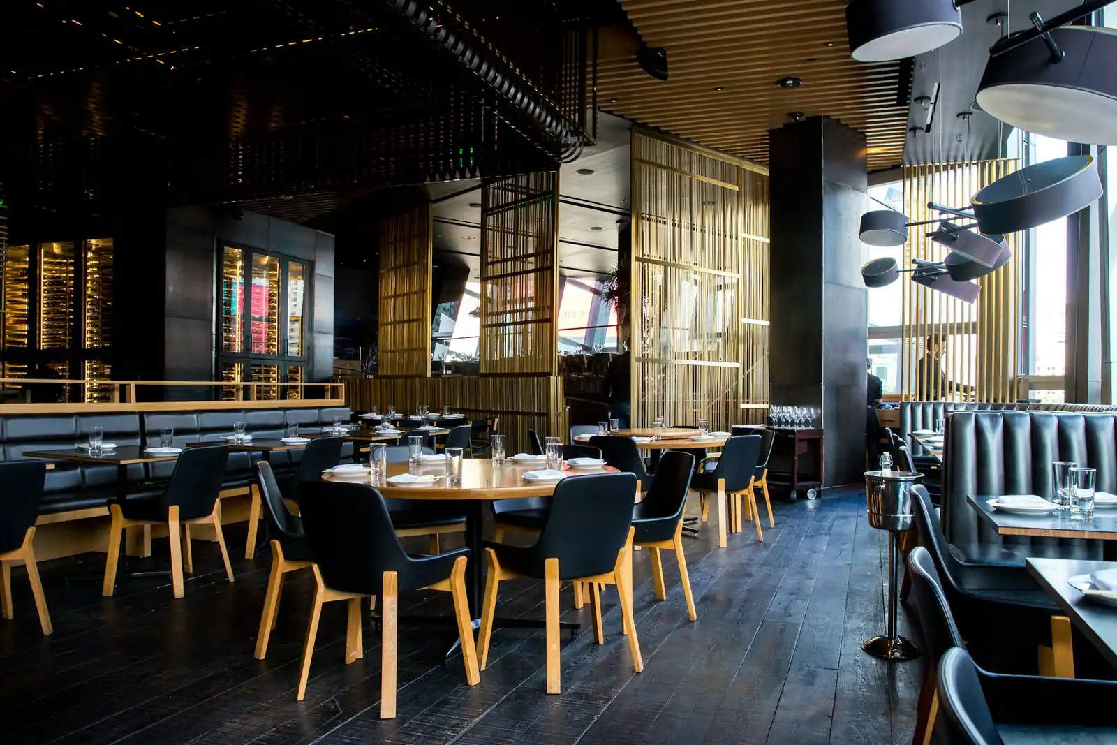 Akşam saatinde ahşap masalı ve deri koltuklu boş restoran salonu